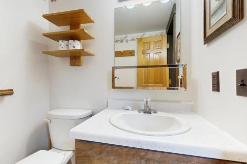 a bathroom with a sink and a toilet and a mirror at Yellowstone 28B in Big Sky