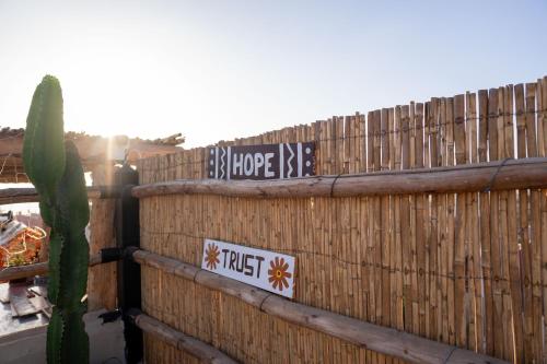 a fence with street signs on it with a cactus at Namaste Lodge Experience in Taghazout