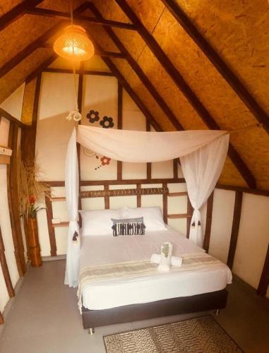 una camera da letto con letto bianco in mansarda di Hotel Cabañas Villa Loe Jardín a Jardin