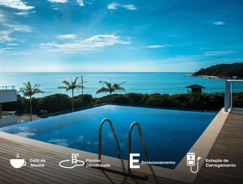 a swimming pool with a view of the ocean at Reserva Praia Hotel in Balneário Camboriú