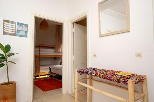 a room with a bench with a mirror and a bedroom at Namaste Lodge Experience in Taghazout
