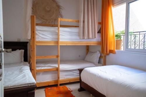two bunk beds in a room with a window at Namaste Lodge Experience in Taghazout