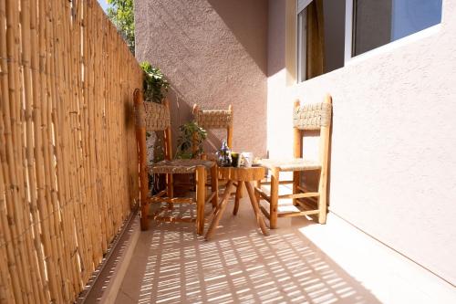 a table and chairs on a patio with a fence at Namaste Lodge Experience in Taghazout