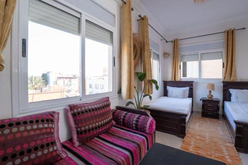 a living room with a couch and a bed at Namaste Lodge Experience in Taghazout