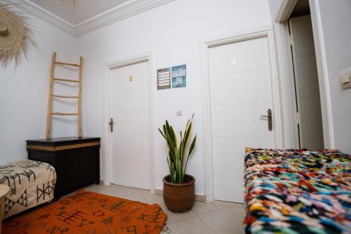 a bedroom with a bed and a ladder and a plant at Namaste Lodge Experience in Taghazout