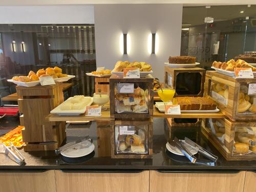 a display case with many different types of food at Quality Suites Vila Velha in Vila Velha