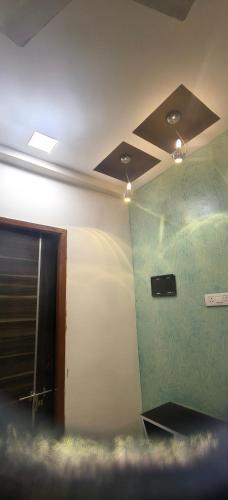 a room with a green wall and a ceiling with lights at Ajith imperial in Mahabalipuram