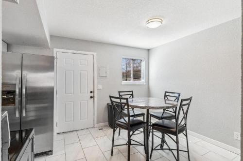 a kitchen with a table and chairs and a refrigerator at All New! Convenient Location! Sleeps 6 in Denver