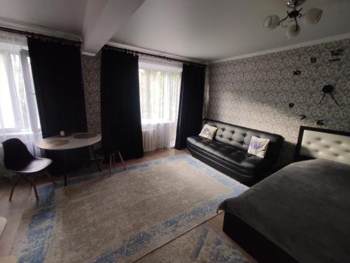 una sala de estar con un sofá y una mesa en Квартира посуточно в Шахтинске, en Shakhtīnsk