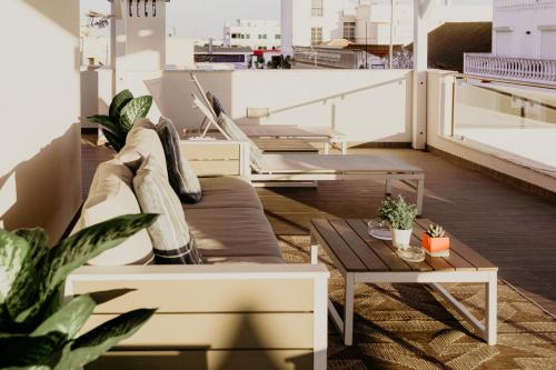 a living room with a couch and tables on a roof at Apartamentos Sol & Ria in Olhão