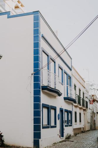 a blue and white building on a street at Apartamentos Sol & Ria in Olhão
