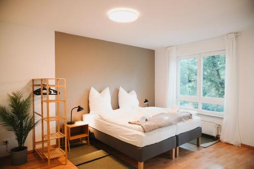 フュルステンヴァルデにあるGemütliche 2-Zimmer-Wohnung in Fürstenwalde an der Spreeの白いシーツと窓のあるベッドのある寝室