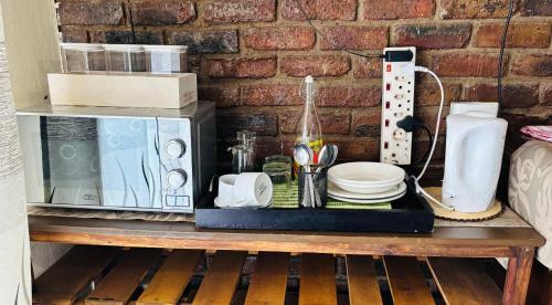 a table with a microwave and dishes on it at Nalana Guest House in Thaba Nchu