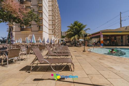 a row of lounge chairs next to a swimming pool at DiRoma Exclusive Caldas Novas in Caldas Novas