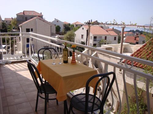 a table with a bottle of wine on a balcony at Apartments Dadic Cavtat in Cavtat