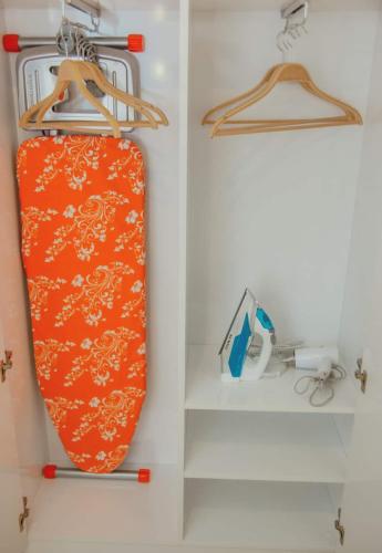 an orange suitcase is hanging in a closet at Glorious Sea View Aparthotel In Orbi City Batumi in Batumi