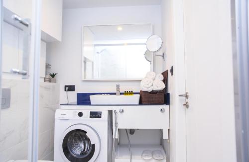a bathroom with a washing machine and a sink at Glorious Sea View Aparthotel In Orbi City Batumi in Batumi