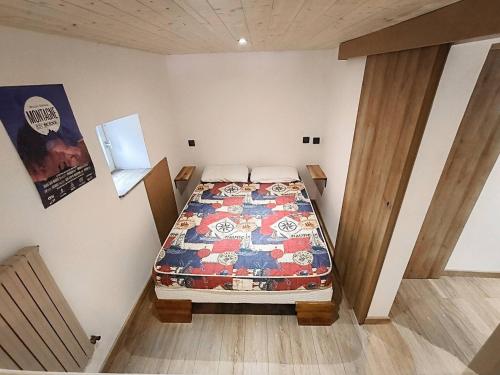 a bedroom with a bed in the corner of a room at COSY T2 Aux Portes des Écrins in Villar-dʼArène