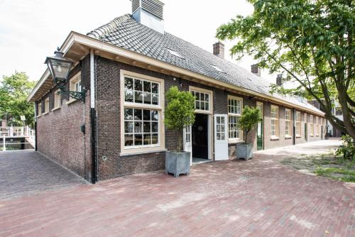 a brick building with two potted plants in front of it at Boutique Hotel d'Oude Morsch in Leiden