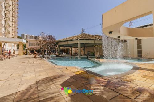 a swimming pool with a fountain in a building at DiRoma Exclusive Caldas Novas in Caldas Novas