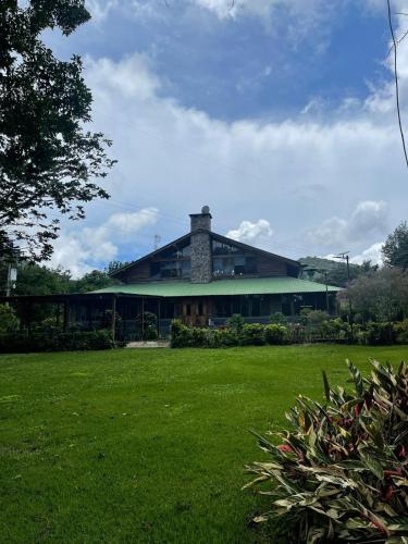 a large building with a green lawn in front of it at Hotel Santa Leticia, Apaneca in Apaneca