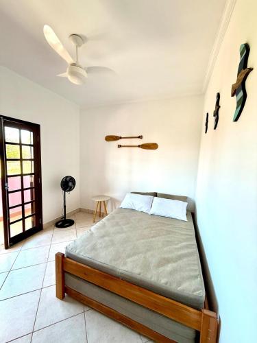 a bedroom with a bed and a ceiling fan at Apartamento à beira-mar Ilha Comprida in Ilha Comprida