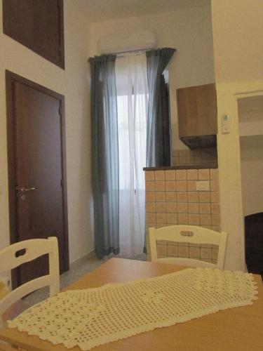 a kitchen with a table and chairs and a window at Arco Michele in Putignano