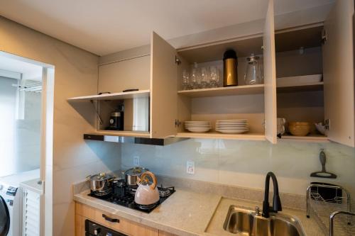 a kitchen with wooden cabinets and a sink at Ap de novela no centro da cidade com garagem in Toledo