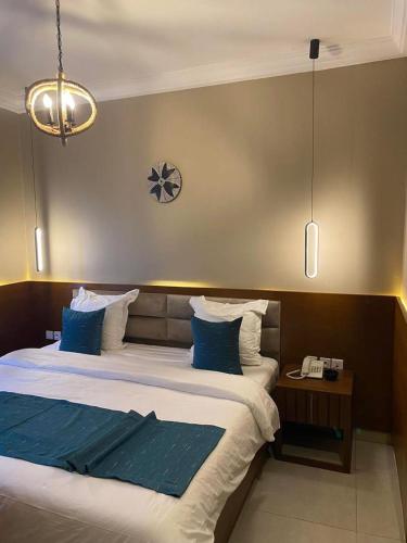 a bedroom with two beds and a clock on the wall at Hotel de l'Air in Douala