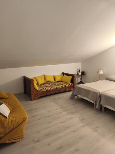 a living room with a couch and two beds at La maison d Adélaïde in Saint-Laurent-dʼAigouze