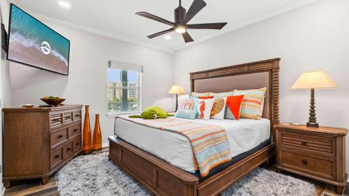 a bedroom with a bed and a ceiling fan at Cozy 3-Bedroom Condo - Comfy Living Space Two Balconies Outdoor Pool Beach Walkable - Score up to 450 Every Day in Tickets for Local Activities in Romar Beach