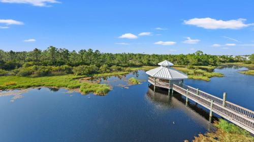 a bridge over a body of water with trees at Cozy 3-Bedroom Condo - Comfy Living Space Two Balconies Outdoor Pool Beach Walkable - Score up to 450 Every Day in Tickets for Local Activities in Romar Beach