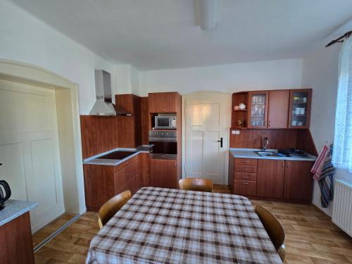 a kitchen with a table with a checkered table cloth at Ubytování Ráďa in Velký Šenov