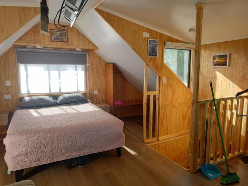 a bedroom with a bed in a room with stairs at Departamento un solo ambiente in Valdivia