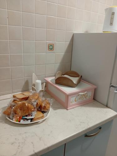 a plate of pastries and a pink box on a counter at Casa Vacanza Luna in Palagiano