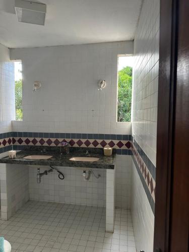 a bathroom with two sinks and a window at Casa de Campo in Eusébio