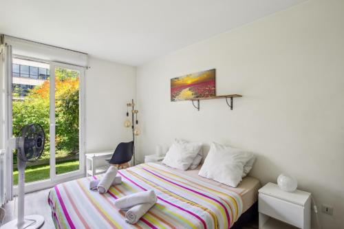 a bedroom with a bed and a window at Beau F2, Paris Stade de France, Jacuzzi, Parking in Saint-Denis