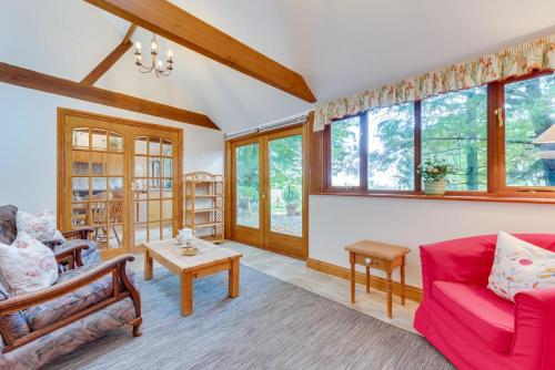 a living room with a red couch and windows at Valley View Barn in Hartfield