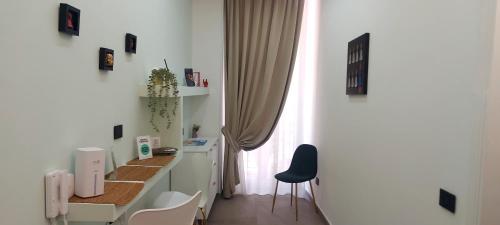 a white room with a desk with a blue chair at Pignasecca Domus in Naples