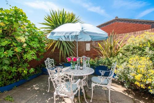 a table and chairs with an umbrella on a patio at 7 Ramey Court in Sheringham