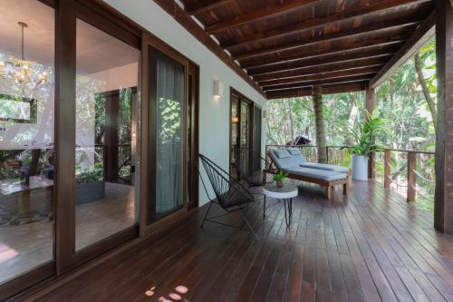 an open porch of a house with a wooden floor at La Zebra Tulum, a Small Luxury Hotel in Tulum