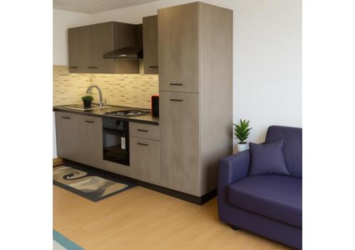 a kitchen with a purple couch and a kitchen with a stove at Chic house in Avezzano
