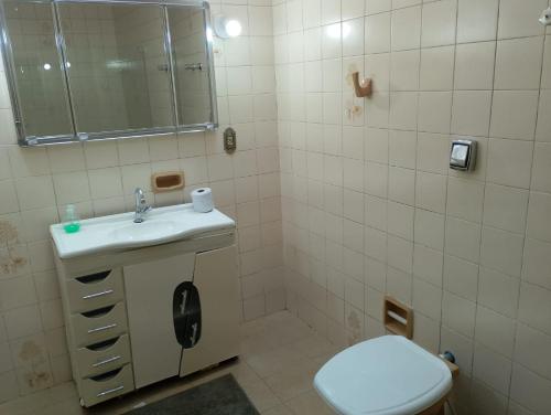 a bathroom with a sink and a toilet and a mirror at Pousada A Cabana in Uruguaiana