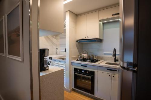 a kitchen with white cabinets and a stove top oven at Studio Nubia centro in Toledo