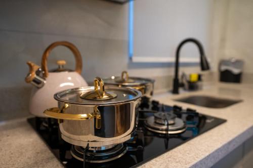three pots and pans on a stove in a kitchen at Studio Nubia centro in Toledo