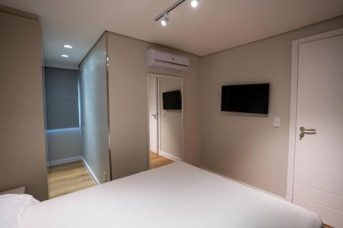 a bedroom with a white bed and a television at Studio Nubia centro in Toledo