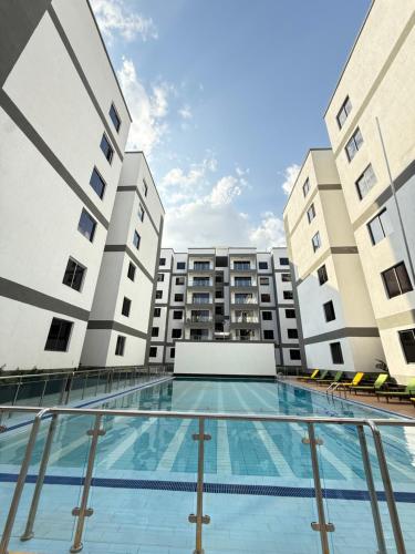 a swimming pool in the middle of two buildings at Oderms cozy apartment with Gym and Swimming Pool in Nairobi near JKIA Airport & SGR in Nairobi