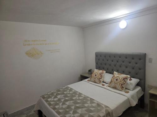 a bedroom with a bed and a sign on the wall at Hotel Rodadero Dorado in Santa Marta