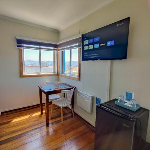 a small room with a table and a television at Hostal Terraza Recreo in Viña del Mar