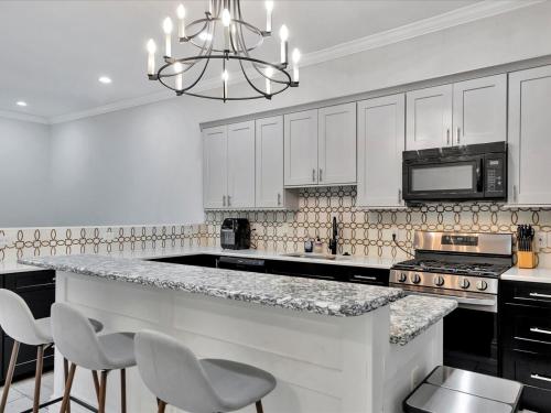 a kitchen with white cabinets and a counter with chairs at Walking Distance to Downtown Free Parking in Tampa